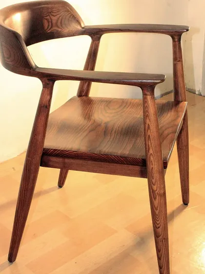 Another angle of the solid wood dining chair, showing how the light catches the polished surface. This is a design that you will love for many years.