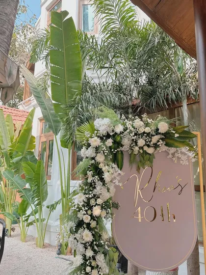 A personalized welcome sign for a 40th birthday, framed by a cascade of white flowers and fresh greenery. This elegant entrance set a sophisticated tone for the milestone celebration.