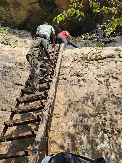 Another view of the group climbing the ladder into the caves.