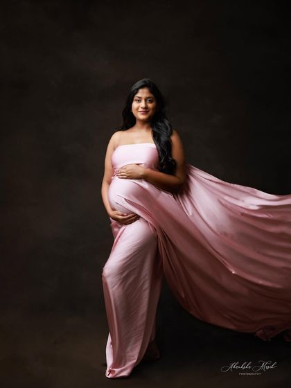 The soft pink satin of this gown catches the light beautifully, creating a portrait that is both gentle and glamorous.