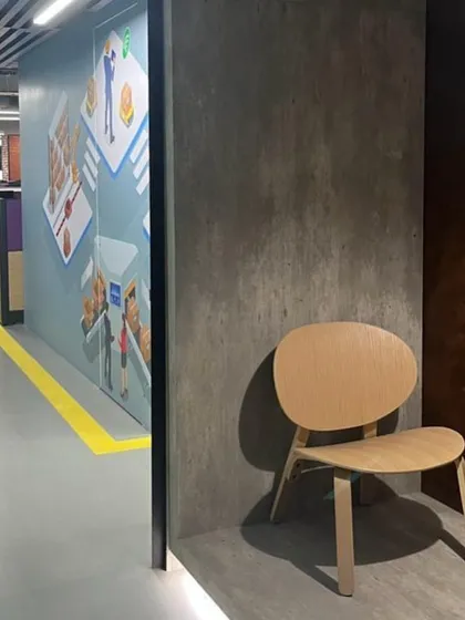 A quiet nook in the FedEx Hyderabad office, featuring a rustic mood board of concrete and corten steel textures. This space demonstrates how industrial materials can be used to create warm and inviting breakout areas.