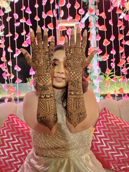 The bride playfully showing off her intricate henna, a true centerpiece of her wedding look.