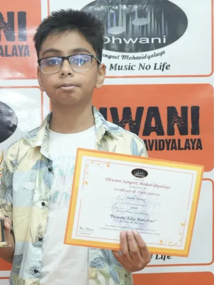 A confident young artist holding his certificate of participation and award. Every student who puts in the effort is a winner in our eyes.