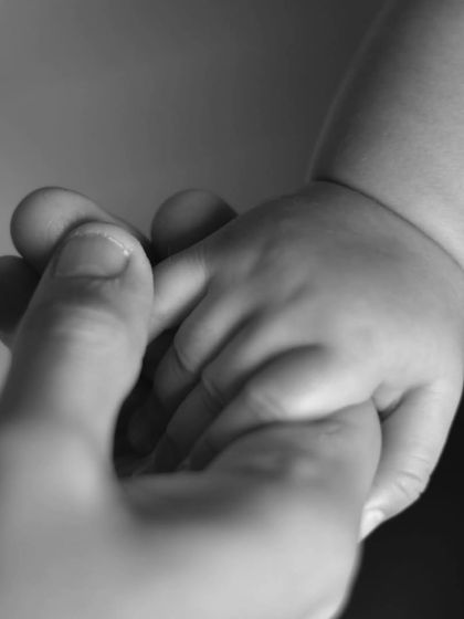 The simple, powerful image of a baby's hand holding an adult's finger. In black and white, this classic shot beautifully represents trust, connection, and love.