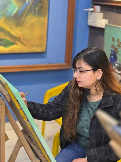 A candid shot of a student at her easel, focused on her ballpoint pen drawing in our creative and inspiring studio space.