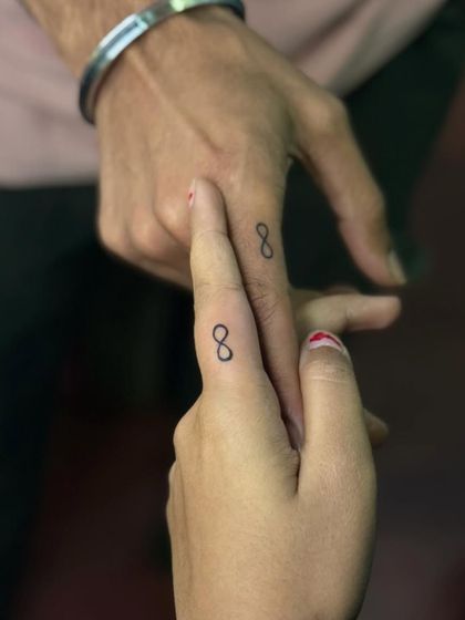 Matching infinity symbol tattoos on the fingers for a couple. This is a popular and subtle way to symbolize an everlasting bond.