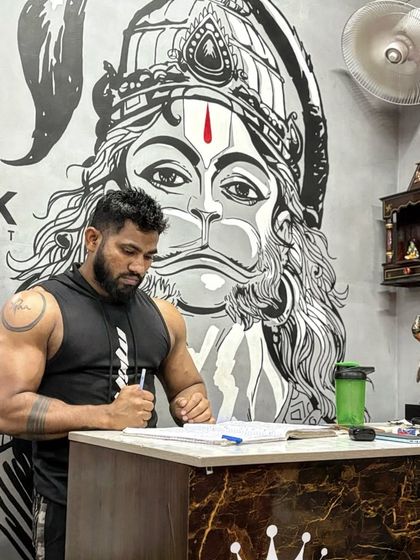 At my desk at the gym, planning workouts for my clients. The Hanuman mural is a constant source of inspiration and strength.