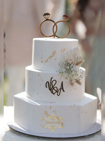 A close-up of the beautiful engagement cake, featuring a custom monogram and delicate floral details.
