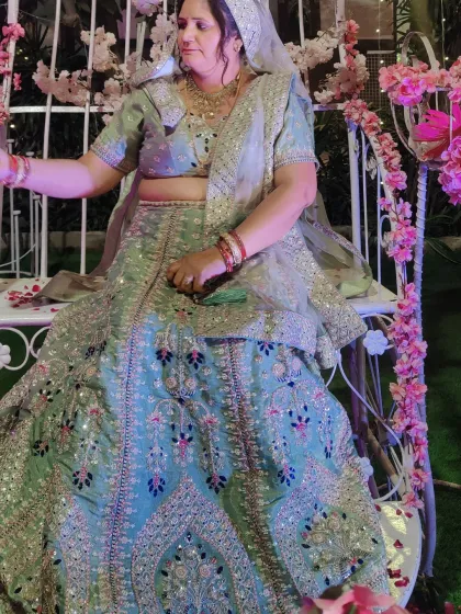 A close-up of the pastel green floral lehenga, showing the detailed embroidery and mirror work.