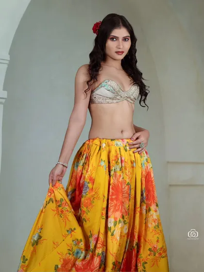 A full-length shot of a model in a vibrant yellow floral skirt. The movement in the skirt adds a playful and dynamic feel to this cheerful studio fashion portrait.