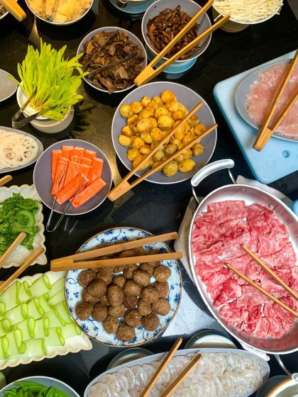 A beautiful spread for a live hot-pot station. Guests can choose from a variety of fresh vegetables, succulent meats, and flavorful broths to create their own perfect bowl.