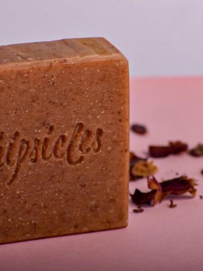 A close-up of the Floral Bliss bar, showing its natural texture from rose petal powder. The scent is a beautiful floral bouquet of Rose, Geranium, and Jasmine essential oils.