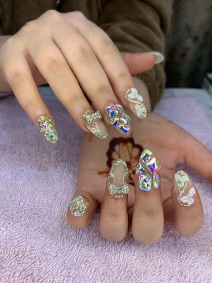 This is a maximalist bridal design for the bride who wants it all. It combines 3D bows, iridescent crystals, and glitter on almond-shaped extensions.