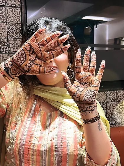 A happy client showing off her party mehandi. This design is a perfect example of a beautiful, balanced pattern for any celebration.