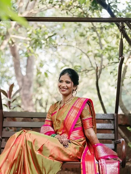A serene portrait of the bride on a garden swing. Surrounded by lush greenery, she looks peaceful and radiant in her traditional silk saree.