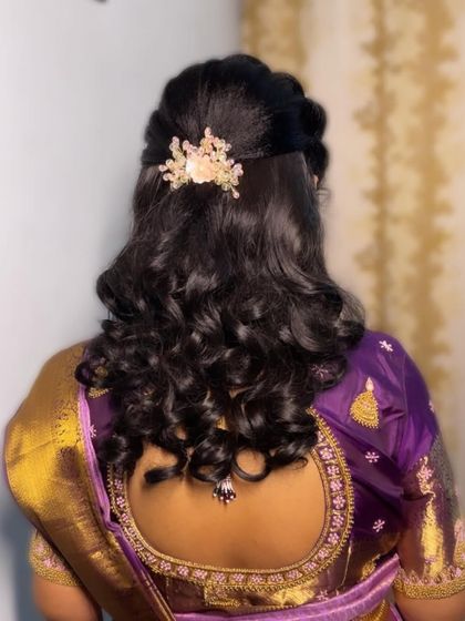 A half-up, half-down hairstyle with soft curls. This is a versatile and popular choice for receptions and parties, adorned with a delicate hair clip.