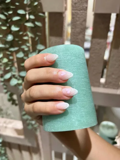 A close-up of the delicate heart detail on this otherwise minimalist and classic nail design.
