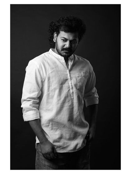 A strong and moody portrait of an actor. The black and white format enhances the dramatic lighting and his serious expression, creating a compelling character study for his portfolio.