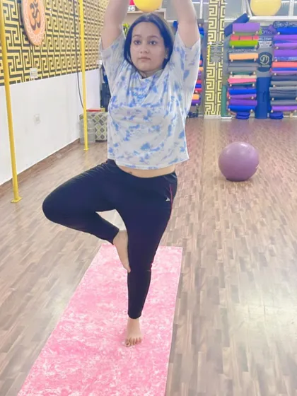 A student finding her balance and stability in the classic tree pose. Every advanced practice is built on a strong foundation of these fundamental asanas.