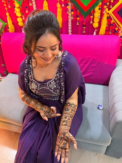 A candid shot of the bride admiring her intricate mehendi, which tells her personal story.