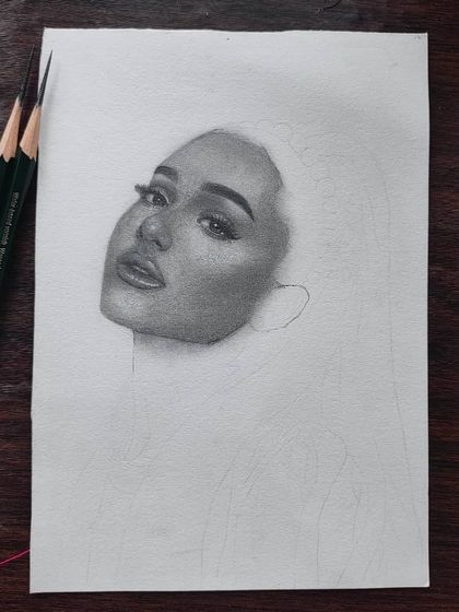 The first stage of the Ariana Grande portrait, showing just the face emerging from the blank paper.