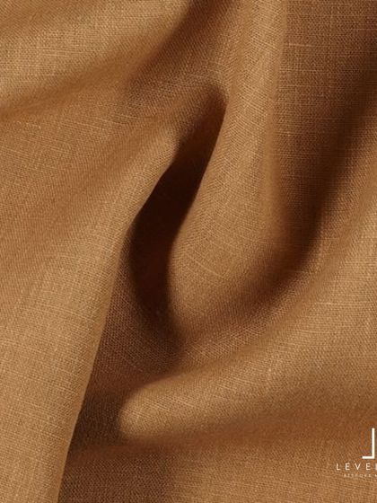 The beautiful texture of a camel-colored linen fabric, a warm and sophisticated choice for summer trousers or a blazer.