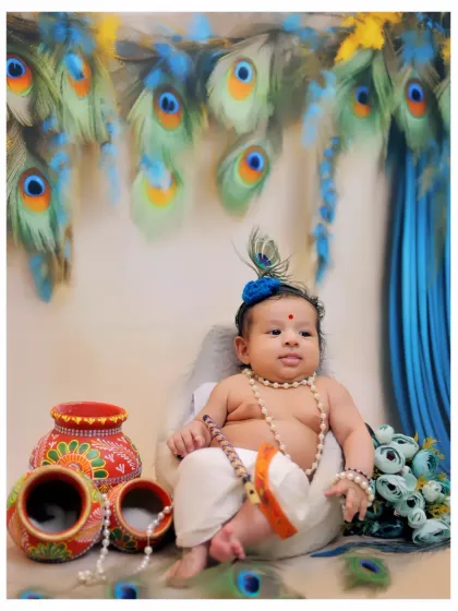 One of my most requested themed photoshoots, this Little Krishna setup features a custom costume, peacock feather backdrop, and traditional props like painted matkas.