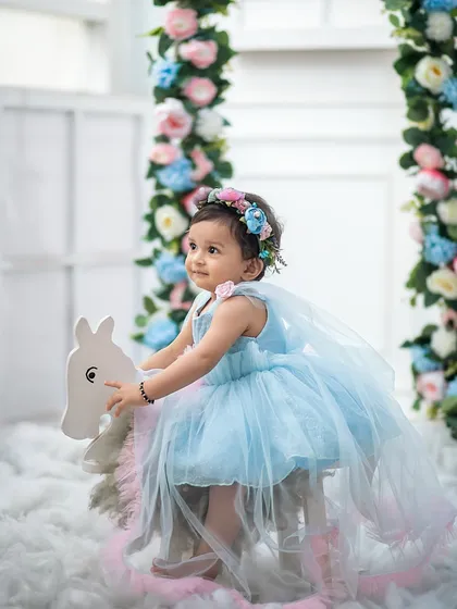 Another beautiful angle of our little fairy on her rocking horse, showcasing the soft tulle of her dress and the lovely floral details.