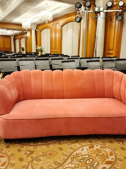We provide stylish furniture to match your event's theme. This chic, scalloped pink velvet sofa adds a touch of retro glamour and a pop of color to the lounge area of a Sangeet party.