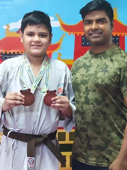 This young champion showcasing his two medals from the Open National Karate Championships. His hard work has truly paid off.