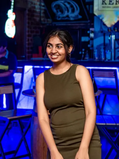 A guest smiling in front of the bar.