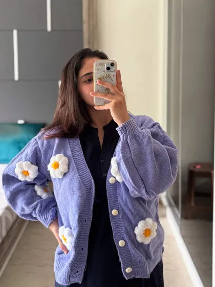A closer look at the Moonlight Cardigan in a lovely purple. You can see the texture of the premium wool and the details on the hand-crocheted daisy flowers that we attach to each piece.