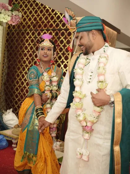A candid shot of the bride and groom sharing a happy moment. The bride's makeup is flawless, highlighting her features and ensuring she looks radiant throughout the ceremony.