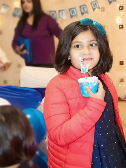 A young girl enjoying a themed cupcake at a Frozen birthday party. I capture the small details that make your party unique.
