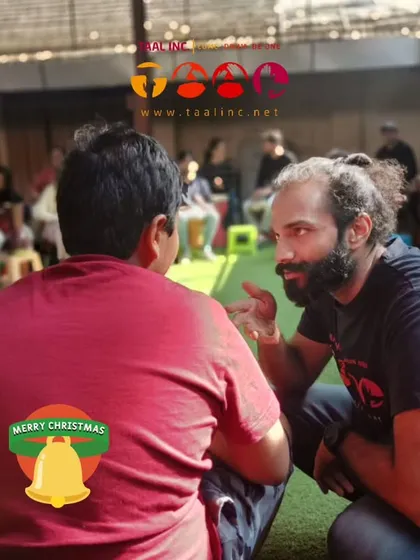 A quiet moment of connection during a community drum circle. Facilitation isn't just about being loud; it's about listening and creating space for one on one interaction.