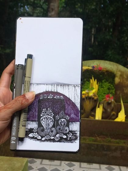 My pen and ink sketch for Nagarapanchami, drawn on-site. I held my sketchbook up to the Naga stones to show the direct inspiration for this intricate, traditional drawing.