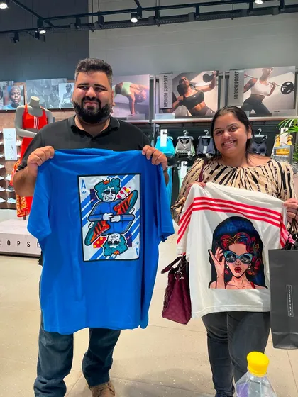 Two happy customers holding up their unique, custom-printed t-shirts from our live activation at the Adidas store. Guests can choose from a range of our original designs to have printed on the spot.