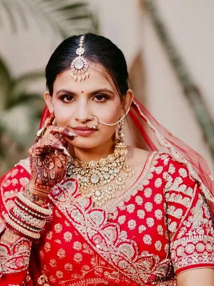 A powerful and confident portrait. The makeup is classic, with a defined eye and a soft lip, perfect for a traditional bride.
