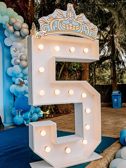 A five-foot-tall marquee number crowned for a princess. This statement piece not only marks the milestone but also serves as a brilliant photo opportunity, adding a touch of modern glamour to the celebration.