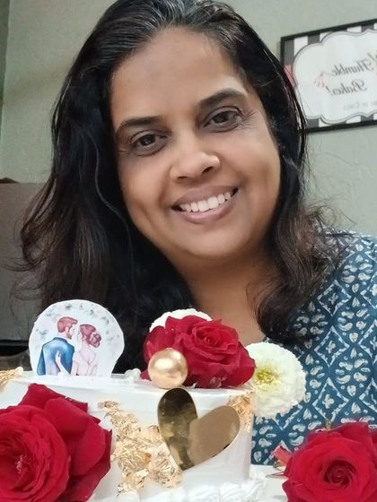 Me with a beautiful anniversary cake decorated with fresh red roses and a golden heart.