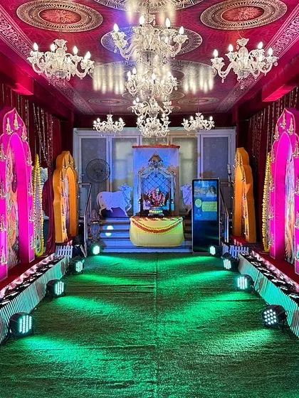 An alternate view of a vibrant passage we designed for a religious ceremony. This setup uses colorful, illuminated panels depicting various deities, creating a dramatic and devotional pathway under a canopy of chandeliers.