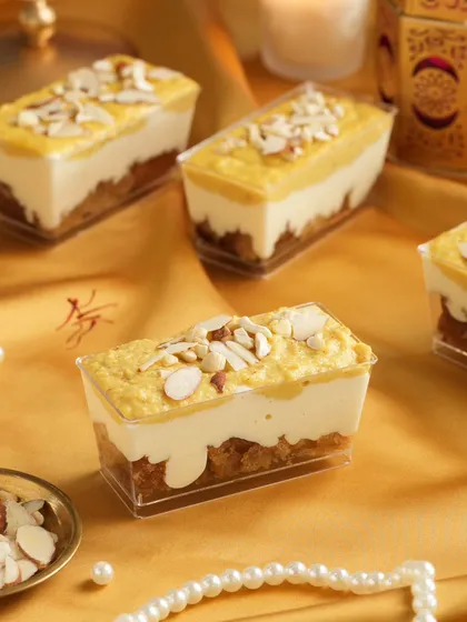 A luxurious shot of Shahi Tukda dessert tubs, styled for a festive Diwali campaign. We used golden fabrics, pearls, and soft lighting to highlight the rich texture and almond garnish.