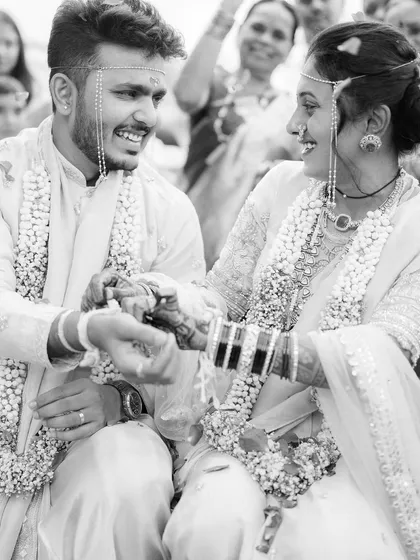 A candid black and white shot of Pratik and Yamini sharing a laugh during their ceremony. It's the unposed, in-between moments like this that tell the most authentic story of a wedding day.