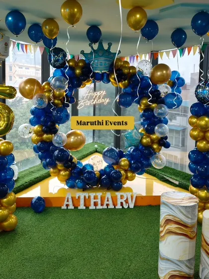 A royal blue and gold themed party for Atharv's 5th birthday. The circular balloon arch is accented with a crown foil balloon and a neon sign.