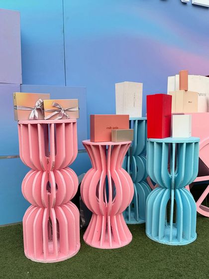 A close-up of the custom-fabricated display stands for the Ajio Luxe event. The unique, curved design in pink and blue adds a modern, artistic touch while elegantly showcasing the luxury products.
