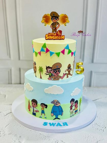 A heroic Little Singham cake for a 5th birthday celebration. This two-tier cake is decorated with the brave police officer and his friends, perfect for a party full of action and adventure.