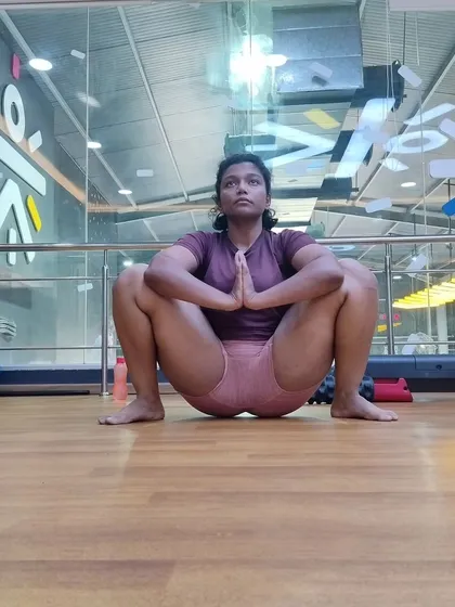 A frontal view of the Malasana pose, focusing on an upright torso and using the elbows to deepen the hip opening. This is a key corrective exercise for anyone with tight hips.