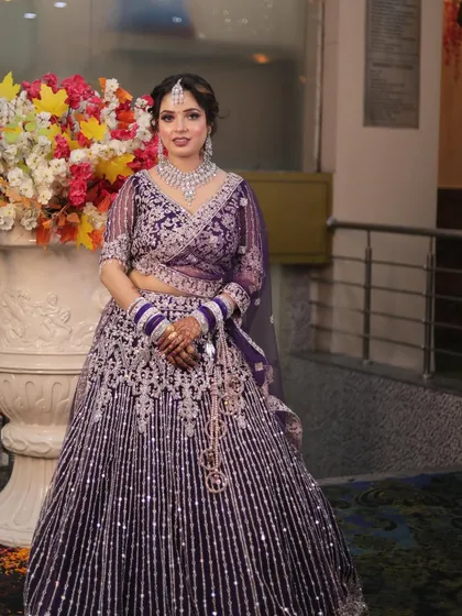 An advanced party makeup look in a stunning purple lehenga. The makeup is glamorous and designed to make a statement.