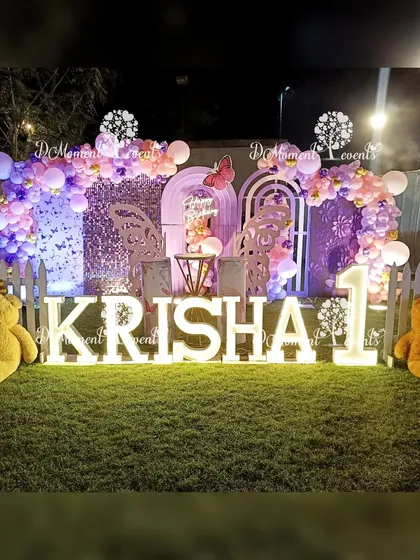 The full outdoor stage setup for Krisha's first birthday, showcasing the symmetrical design with teddy bears, butterfly wings, and balloon-adorned backdrops.