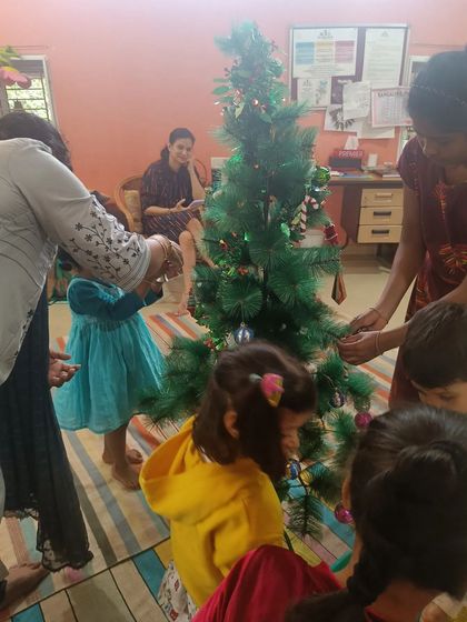 A duplicate shot of the children decorating the Christmas tree.